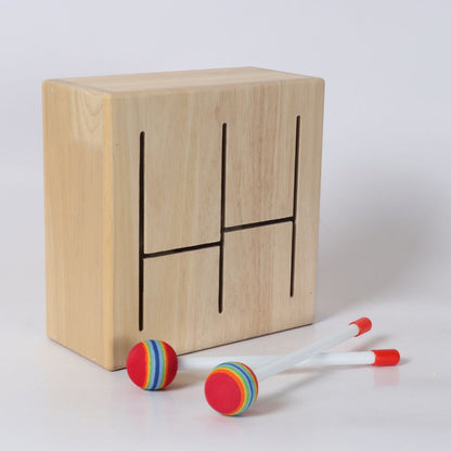 Detalle de la caja de madera de la batería BubuMagic con baquetas. Instrumento musical educativo.