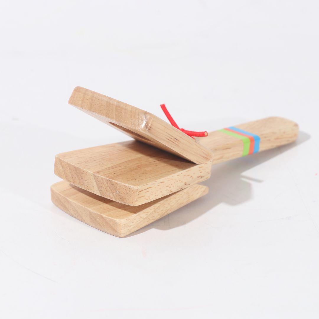 Niño tocando castañuelas de madera BubuMagic. Instrumento musical educativo para aprender ritmo.