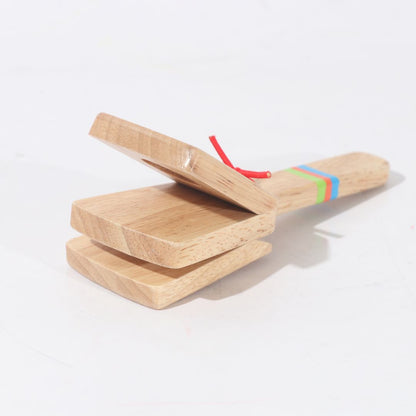 Niño tocando castañuelas de madera BubuMagic. Instrumento musical educativo para aprender ritmo.
